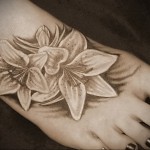 Значение татуировки лилия 10 - Пример татуировки с рисунком лилии - тату белый цветок внизу ноги девушки