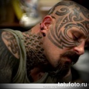 Фото тату: сложный узор в стиле трайбл, покрывающий голову и шею мужчины.