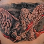 Татуировка ангел с мечом выполненная между лопатками