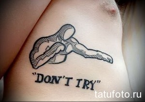 Фото тату руки, тянущейся к другой руке, с надписью "Don't Try". Простой и лаконичный рисунок в черном цвете. Символичный эскиз тату, призывающий к поддержке.