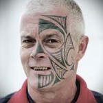 взрослый мужчина с тату маори на лице