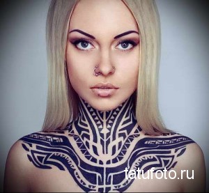 Фото тату в стиле трайбл, покрывающего шею и плечи. Татуировка выполнена черными чернилами с использованием геометрических узоров.