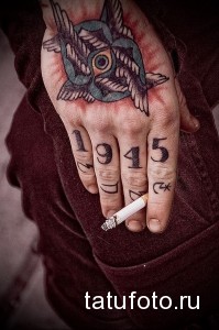 Фото татуировки на руке с изображением двух ласточек и даты "1945". Старый стиль, традиционный дизайн, патриотический символ.