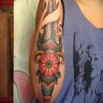 женская татуировка на руку с ножом и цветами - цветная татуировка на фото