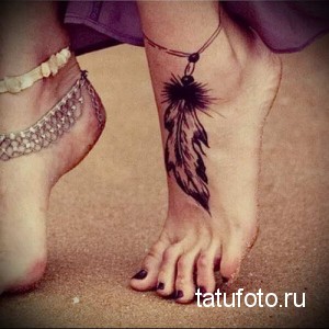 Фото тату: черное перо с бусинами, украшающее женскую лодыжку. Стильная и минималистичная татуировка.
