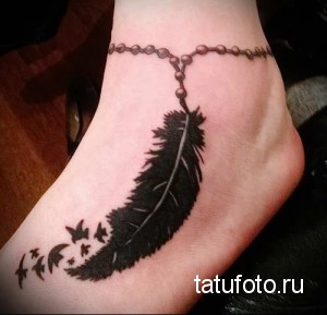 Фото тату: черное перо с вылетающими птицами, украшающее женскую лодыжку. Изысканный рисунок татуировки, выполненный в реалистичном стиле.