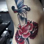 кинжал и цветы роз - женская татуировка на боку