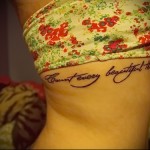 красивая надпись прописными буквами - женская татуировка на боку