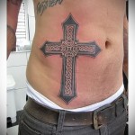 крест с узорами в тату на боку у мужчины