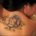 лев и вензеля в рамке тату на спине женская
