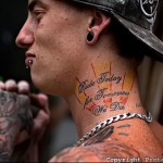 лучи восходящего солнца и надписи - татуировка на шее мужчины - фото