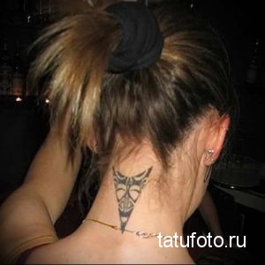 Фото татуировки с изображением племенного узора на затылке. Черный рисунок в стиле трайбл, расположенный вертикально.