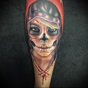 Фото тату: татуировка в стиле Day of the Dead с изображением девушки-черепа на руке. Яркий и детализированный рисунок татуировки.