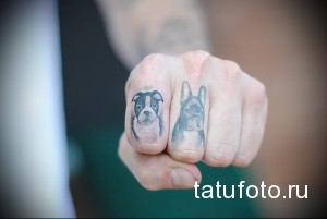 Фото тату двух маленьких собачек разных пород на фалангах пальцев. Черно-серый рисунок татуировки в реалистичном стиле.