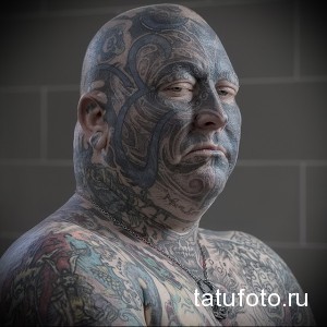 Фото тату: Мужчина с полностью покрытым татуировками лицом и шеей в стиле трайбл. Детализированный рисунок, темные тона.