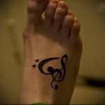 музыкальный рисунок - татуировка в нижней части ноги девушки