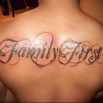 надпись family first (семья превыше всего) - тату мужская на спине фото