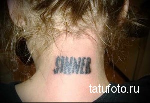 Фото тату на затылке: надпись "SINNER", выполненная в готическом стиле. Дерзкая и провокационная татуировка для смелых личностей.