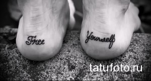 Фото тату: на стопах размещены надписи 'Free Yourself' (Освободи себя) черным шрифтом. Простой и вдохновляющий дизайн.