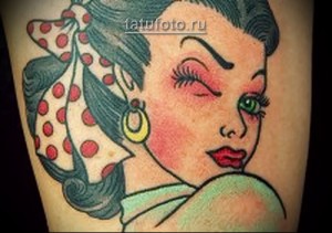 Фото тату на предплечье: девушка в стиле ретро с бантиком на голове. Яркий и красочный рисунок татуировки в стиле олдскул.
