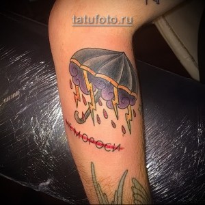 Фото татуировки зонта, из которого льет дождь, с надписью "Не морось" на руке.