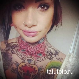 Фото тату: большая татуировка в стиле олдскул, покрывающая шею и плечи. Изображены розы, сердце, надпись и другие традиционные элементы.