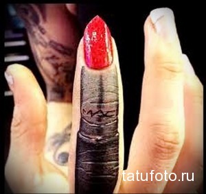 Фотография женской руки с татуировкой помады. Реалистичная татуировка черным и красным цветом.