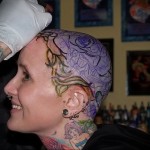 процесс нанесения татуировки в цвете на голову девушке