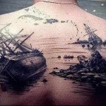 Фото тату на спине с изображением двух затонувших кораблей и скалистого берега. Черно-белый рисунок с детальной проработкой.