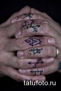 Фото тату: на пальцах рук изображены различные мистические символы и руны, выполненные черными линиями.