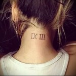 Фото тату на затылке: римские цифры IX III, выполненные в минималистичном стиле. Небольшой и стильный рисунок татуировки для девушек и парней.