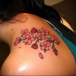 розовые цветы в татуировке на лопатке