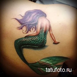 Фото тату: красивая русалка с длинными фиолетовыми волосами, расположенная на лопатке. Эскиз татуировки, маскирующий шрамы на спине.