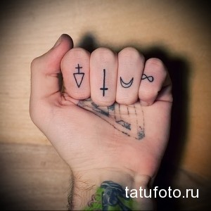 Фото тату на пальцах рук с изображением мистических символов: треугольник, крест, полумесяц и знак бесконечности.