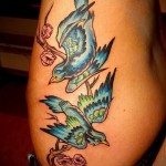 синие птички на ветке дерева - женская татуировка на боку