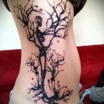 скелетики и дерево - женская татуировка на боку