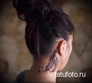 Черно-белое фото татуировки с изображением пера на затылке девушки. Детализированный рисунок пера с тонкими линиями и точками.