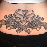 скрещенные пистолеты и сердце - женская татуировка на пояснице