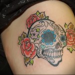 смешной череп с цветочками в татуировке на ногу для девушки