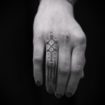 Фото тату: черно-белая геометрическая татуировка на тыльной стороне руки. Сочетание ромбов, линий и точек, минималистичный дизайн.