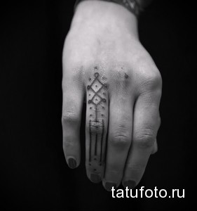 Фото тату: черно-белая геометрическая татуировка на тыльной стороне руки. Сочетание ромбов, линий и точек, минималистичный дизайн.