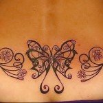 тату бабочка и цветки сакуры с завитками - татуировка на пояснице женская фото