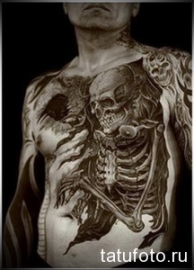 Фото тату скелета на груди и животе. Реалистичный и мрачный рисунок в черно-серых тонах, с детальной проработкой костей и мышц.