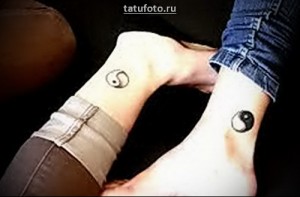 Фото парных тату Инь и Ян на запястьях. Символы выполнены в черном цвете и расположены на внутренней стороне запястий.