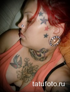 Фото тату на груди и шее девушки. Изображены звезды, ласточки и череп. Стиль татуировки - традиционный.
