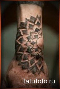 Фото тату мандалы на предплечье, выполненной в технике blackwork. Сложный геометрический узор с использованием черных чернил и точечной техники.