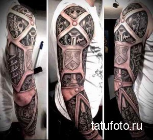 Черно-серая татуировка в стиле биомеханика на руке, изображающая механические детали, интегрированные в анатомию тела, с черепом в центре. Детализированная проработка.