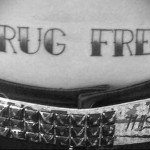Фото тату надписи 'Drug Free' на животе. Черно-белый рисунок с простым шрифтом, символизирующий отказ от наркотиков.