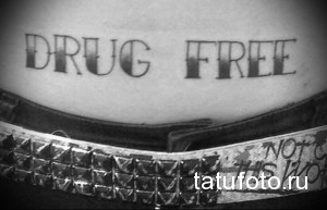 Фото тату надписи 'Drug Free' на животе. Черно-белый рисунок с простым шрифтом, символизирующий отказ от наркотиков.
