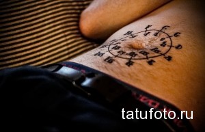 Фото тату музыкальной гаммы на животе. Черно-белый рисунок с нотами и символами, расположенными по кругу.